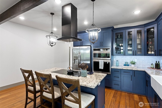 321 W Berry Ridge Rd, Shelton, WA 98584 - kitchen with stainless steel appliances, blue cabinets, island exhaust hood, glass insert cabinets, and recessed lighting