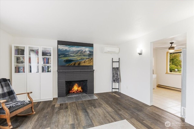 8315 NW 7th Ave, Vancouver, WA 98665 - living room with a wall unit AC, wood finished floors, a fireplace, a baseboard radiator, and ceiling fan