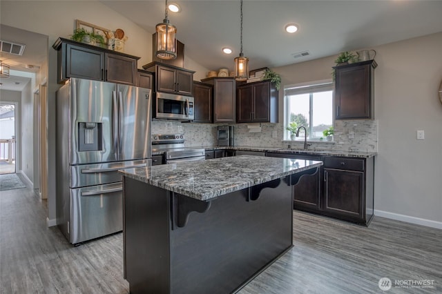 184 S Razor Clam Dr SW, Ocean Shores, WA 98569 - kitchen featuring appliances with stainless steel finishes, dark brown cabinets, stone counters, backsplash, and light wood finished floors