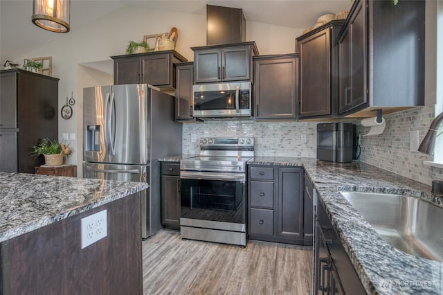 184 S Razor Clam Dr SW, Ocean Shores, WA 98569 - kitchen with stainless steel appliances, a sink, lofted ceiling, dark stone countertops, and dark brown cabinetry