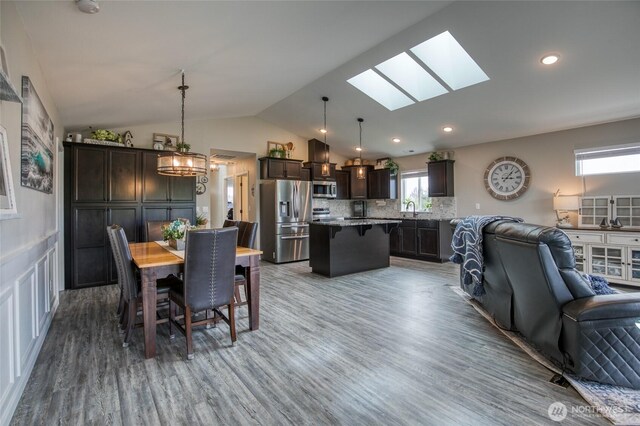 184 S Razor Clam Dr SW, Ocean Shores, WA 98569 - dining area featuring wood finished floors, vaulted ceiling, a skylight, a chandelier, and recessed lighting