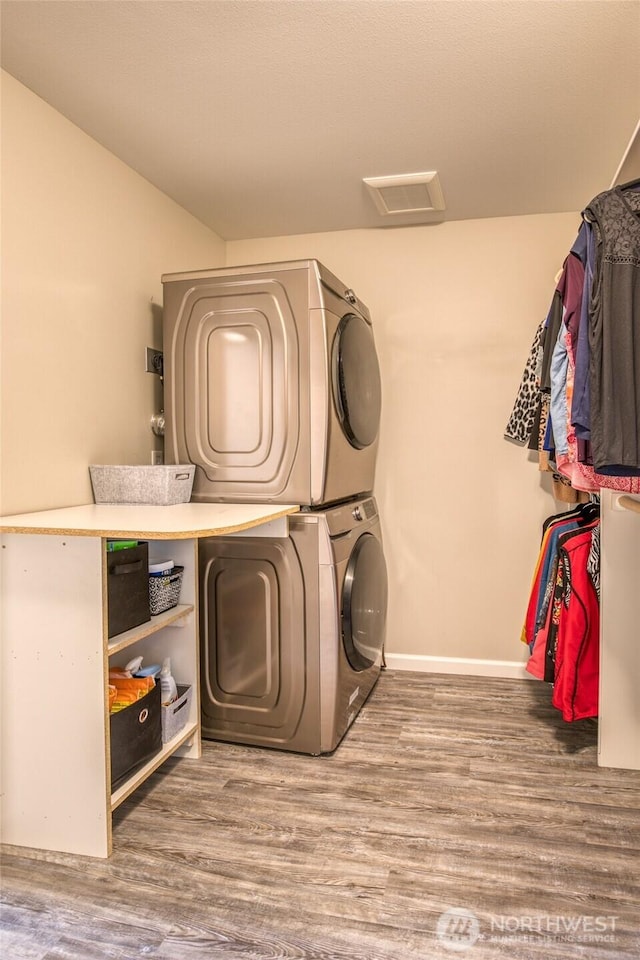 184 S Razor Clam Dr SW, Ocean Shores, WA 98569 - laundry area featuring stacked washer / drying machine, wood finished floors, and baseboards