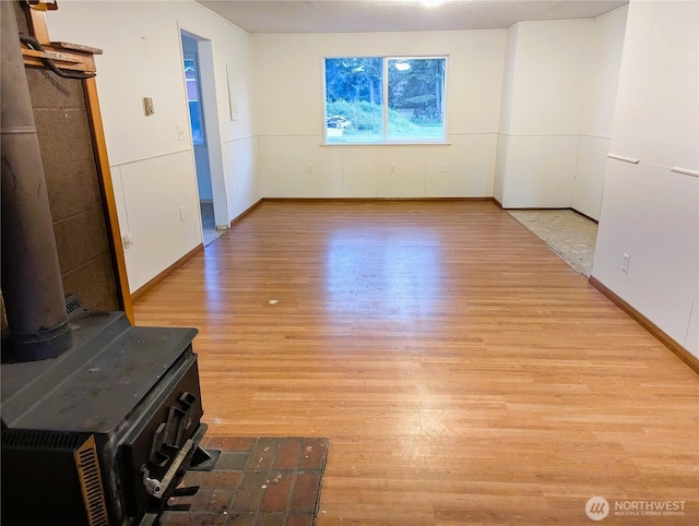 8927 178th Ave SW, Rochester, WA 98579 - unfurnished living room featuring wood finished floors, baseboards, and a wood stove