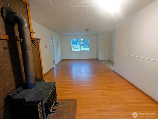 8927 178th Ave SW, Rochester, WA 98579 - unfurnished living room featuring a wood stove and light wood-style flooring
