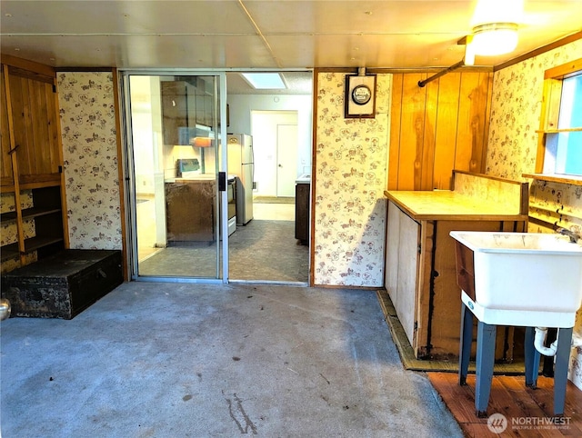 8927 178th Ave SW, Rochester, WA 98579 - kitchen with wallpapered walls, electric range oven, freestanding refrigerator, a sink, and carpet