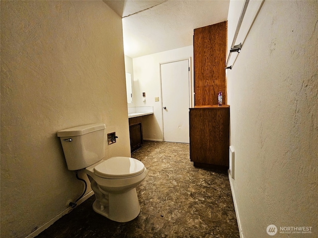 8927 178th Ave SW, Rochester, WA 98579 - bathroom featuring toilet, a textured wall, stone finish flooring, and vanity