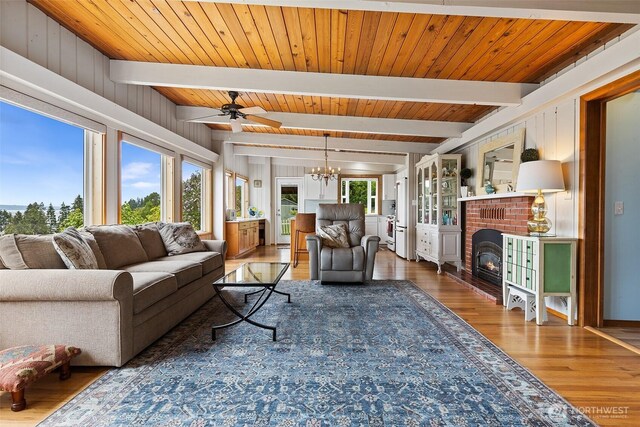 91 N Terrace Rd, Hoodsport, WA 98548 - living room featuring wood finished floors, a chandelier, a brick fireplace, ceiling fan, and wooden ceiling with exposed beams