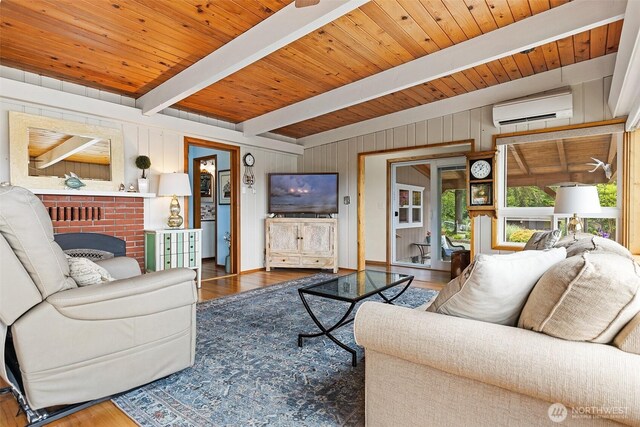 91 N Terrace Rd, Hoodsport, WA 98548 - living room with a wall unit AC, wood finished floors, beam ceiling, and wooden walls