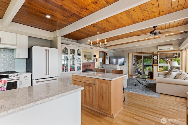 91 N Terrace Rd, Hoodsport, WA 98548 - kitchen with freestanding refrigerator, open floor plan, range with gas cooktop, a wall unit AC, and light wood finished floors