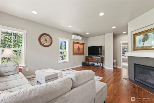 190 E Country Club Dr W, Union, WA 98592 - living room featuring a wall unit AC, dark wood-style floors, recessed lighting, a tiled fireplace, and baseboards