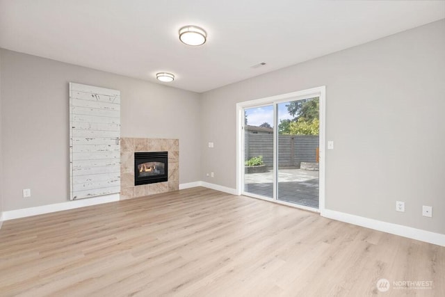 22014 48th Avenue Ct E, Spanaway, WA 98387 - unfurnished living room featuring wood finished floors, baseboards, and a tile fireplace