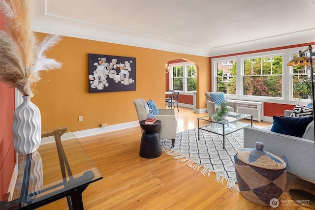 1605 E Olive St Unit 111, Seattle, WA 98122 - living room with arched walkways, wood finished floors, radiator, baseboards, and ornamental molding