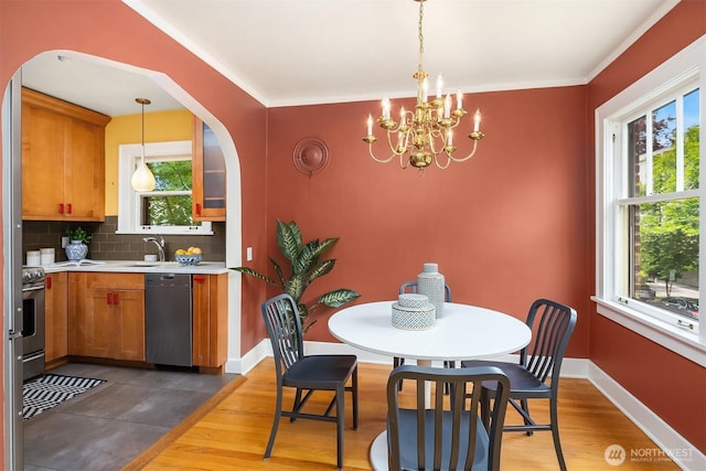 1605 E Olive St Unit 111, Seattle, WA 98122 - dining room featuring a chandelier, dark wood-style flooring, arched walkways, crown molding, and baseboards
