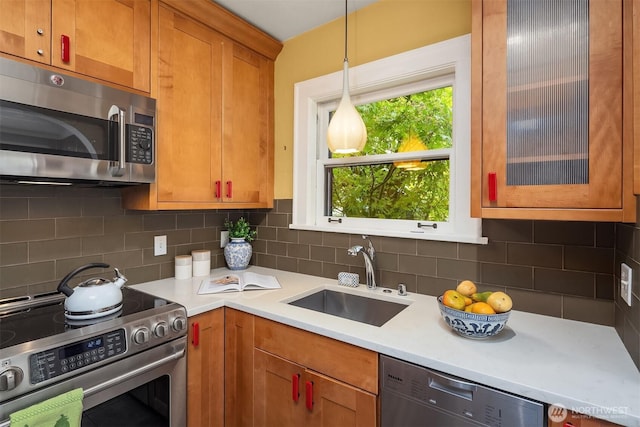 1605 E Olive St Unit 111, Seattle, WA 98122 - kitchen with stainless steel appliances, a sink, light countertops, tasteful backsplash, and decorative light fixtures