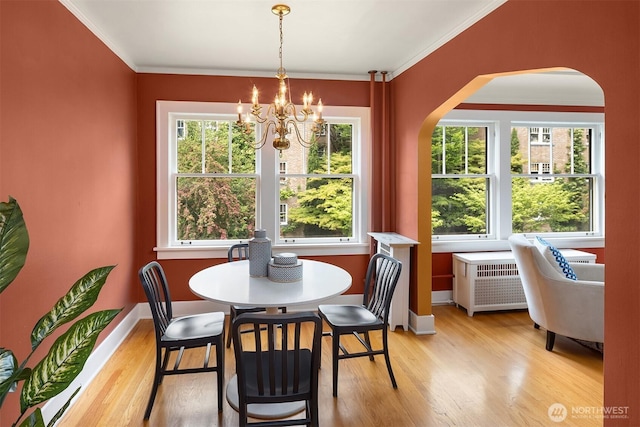 1605 E Olive St Unit 111, Seattle, WA 98122 - dining room featuring arched walkways, light wood-style flooring, a chandelier, plenty of natural light, and ornamental molding
