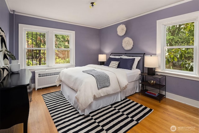 1605 E Olive St Unit 111, Seattle, WA 98122 - bedroom with radiator heating unit, multiple windows, wood finished floors, ornamental molding, and baseboards