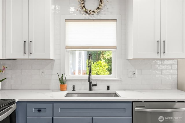 5116 N 40th St, Tacoma, WA 98407 - kitchen featuring stainless steel dishwasher, a sink, white cabinetry, light stone counters, and decorative backsplash