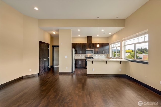 4020 NE 3rd Pl Unit B, Renton, WA 98056 - kitchen featuring stainless steel appliances, dark brown cabinets, a breakfast bar, dark wood finished floors, and recessed lighting