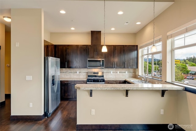 4020 NE 3rd Pl Unit B, Renton, WA 98056 - kitchen with appliances with stainless steel finishes, dark wood finished floors, a sink, a breakfast bar, and tasteful backsplash