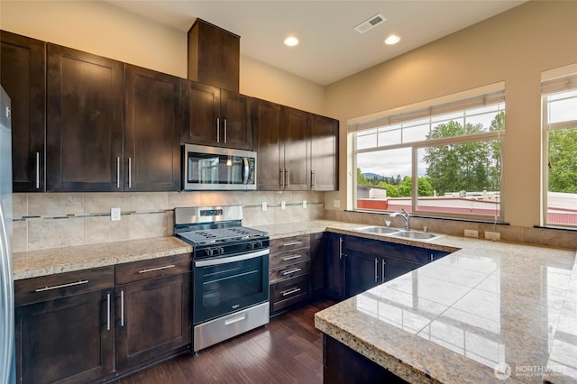 4020 NE 3rd Pl Unit B, Renton, WA 98056 - kitchen featuring appliances with stainless steel finishes, a sink, dark brown cabinetry, tasteful backsplash, and recessed lighting