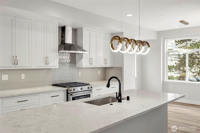 6726 NE 187th St Unit 104, Kenmore, WA 98028 - kitchen featuring wall chimney range hood, stainless steel stove, light wood-style floors, a sink, and decorative backsplash