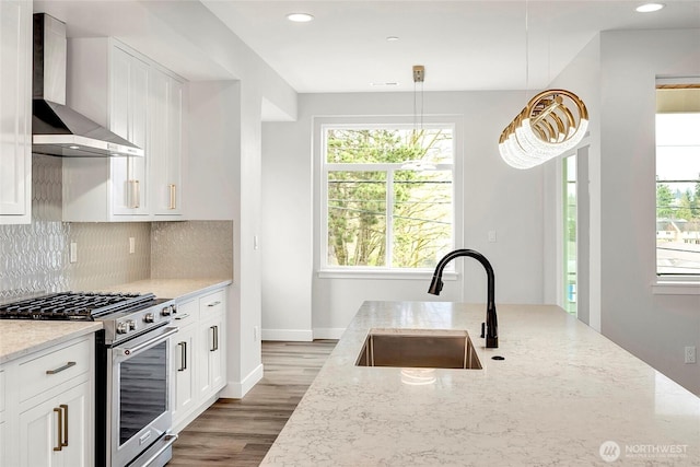 6726 NE 187th St Unit 104, Kenmore, WA 98028 - kitchen with wall chimney exhaust hood, stainless steel range with gas stovetop, a sink, light stone countertops, and plenty of natural light