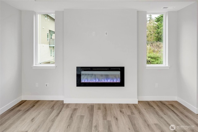 6726 NE 187th St Unit 104, Kenmore, WA 98028 - unfurnished living room with plenty of natural light, wood finished floors, and baseboards