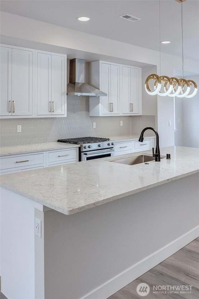 6726 NE 187th St Unit 104, Kenmore, WA 98028 - kitchen featuring wall chimney exhaust hood, a sink, stainless steel range, white cabinets, and recessed lighting