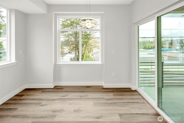 6726 NE 187th St Unit 104, Kenmore, WA 98028 - unfurnished dining area with a chandelier, baseboards, and light wood-style floors