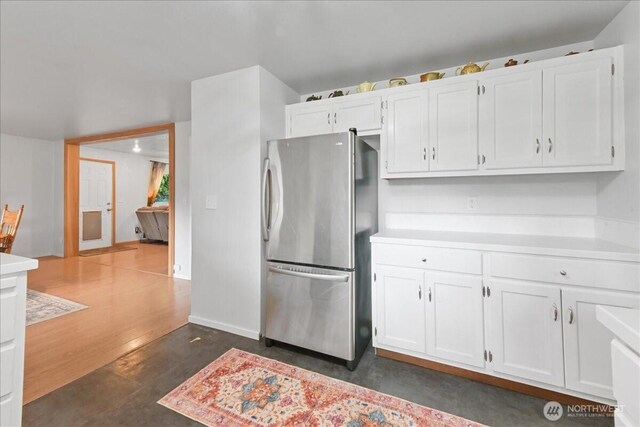 32509 80th Dr NW, Stanwood, WA 98292 - kitchen with freestanding refrigerator, white cabinets, light countertops, and baseboards