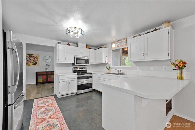 32509 80th Dr NW, Stanwood, WA 98292 - kitchen featuring stainless steel appliances, a peninsula, light countertops, and white cabinets