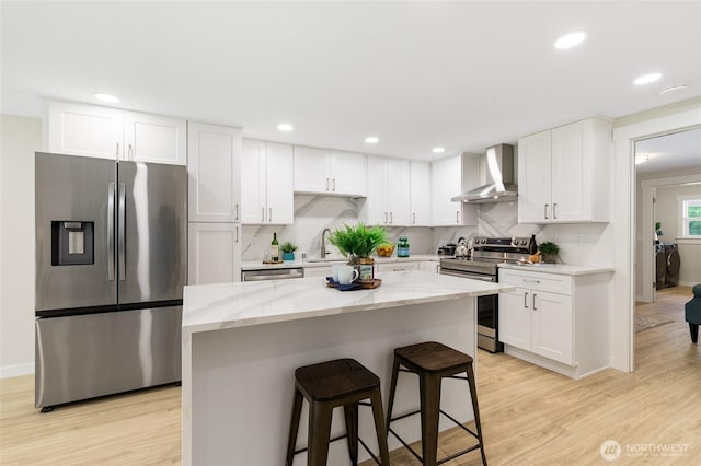 20103 75th Ave NE, Kenmore, WA 98028 - kitchen with appliances with stainless steel finishes, wall chimney exhaust hood, light wood-type flooring, white cabinetry, and recessed lighting