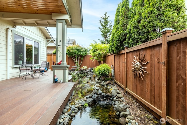 wooden terrace featuring a fenced backyard