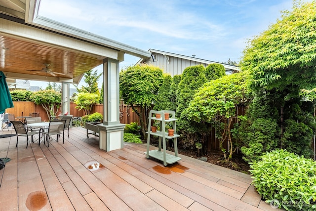 deck featuring ceiling fan, outdoor dining area, and a fenced backyard