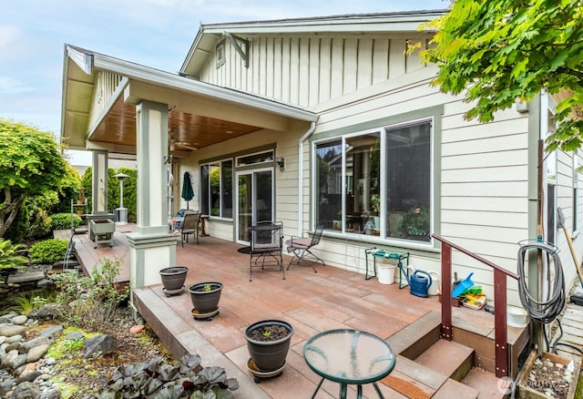 back of house with board and batten siding and a wooden deck
