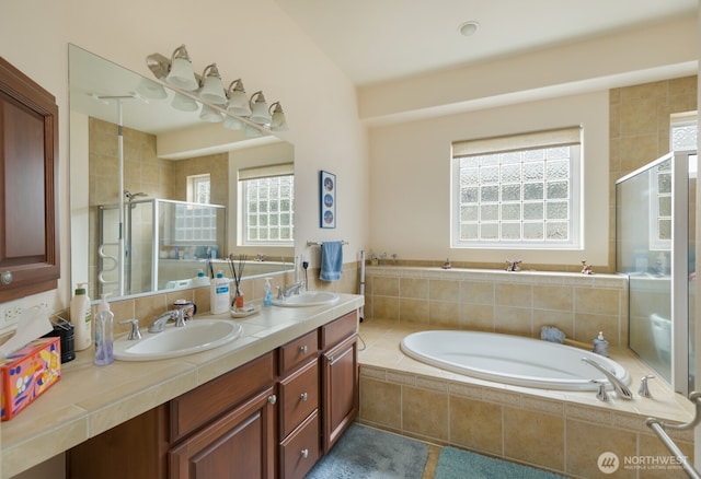 bathroom with a shower stall, double vanity, and a garden tub