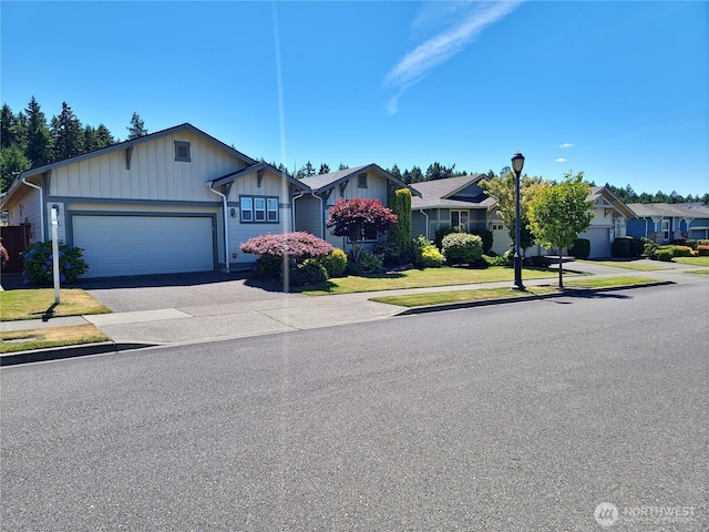 8516 Bainbridge Loop NE, Lacey, WA 98516 - view of front of property featuring board and batten siding, a garage, driveway, a front yard, and a residential view