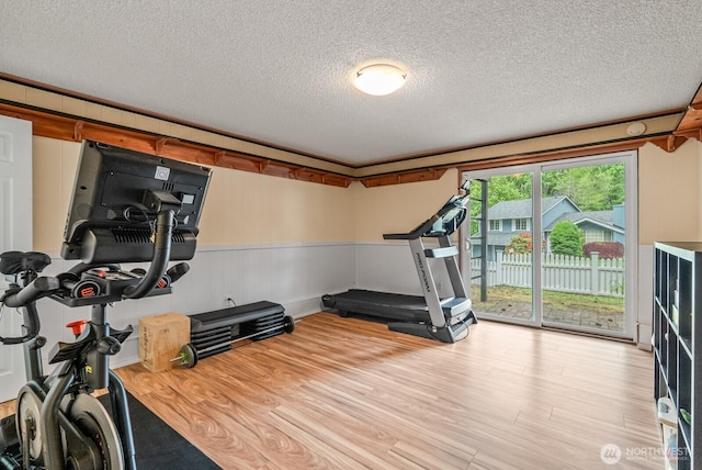 1933 Dayton Dr SE, Renton, WA 98055 - exercise area with wood finished floors, a textured ceiling, and a wainscoted wall