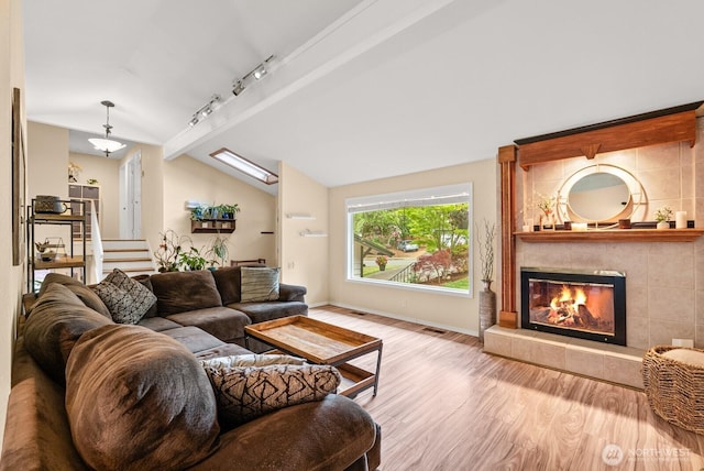 1933 Dayton Dr SE, Renton, WA 98055 - living room with lofted ceiling, wood finished floors, a fireplace, track lighting, and baseboards