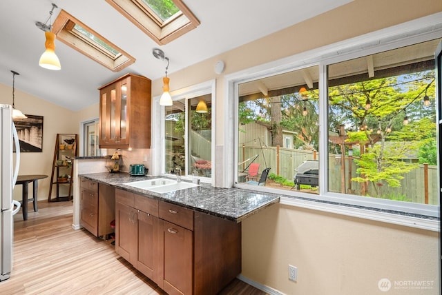 1933 Dayton Dr SE, Renton, WA 98055 - kitchen with a skylight, lofted ceiling, a sink, light wood finished floors, and pendant lighting