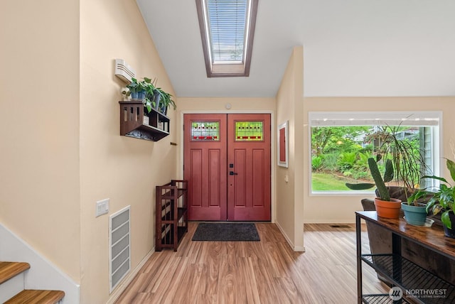 1933 Dayton Dr SE, Renton, WA 98055 - foyer featuring light wood finished floors, baseboards, stairway, lofted ceiling, and a skylight