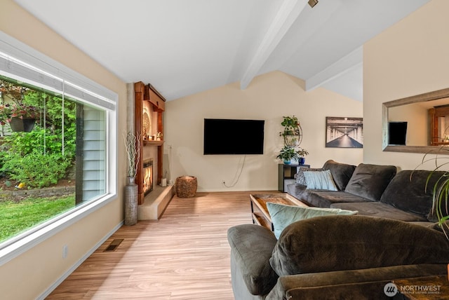 1933 Dayton Dr SE, Renton, WA 98055 - living area with healthy amount of natural light, baseboards, light wood-style floors, and a lit fireplace
