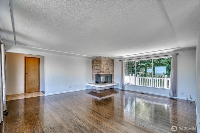 1245 SW 301st St, Federal Way, WA 98023 - unfurnished living room featuring a textured ceiling, wood finished floors, a fireplace, and baseboards
