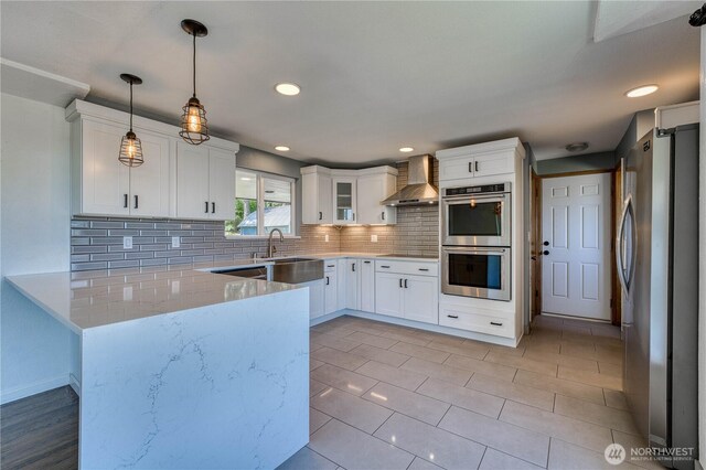 1245 SW 301st St, Federal Way, WA 98023 - kitchen featuring appliances with stainless steel finishes, wall chimney exhaust hood, a sink, backsplash, and white cabinetry