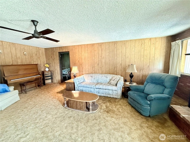 718 Ridge Pl, Omak, WA 98841 - living area featuring a textured ceiling, carpet floors, wooden walls, and a ceiling fan