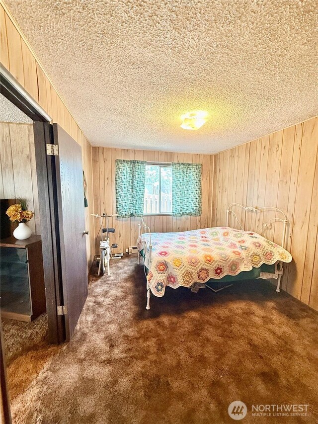 718 Ridge Pl, Omak, WA 98841 - carpeted bedroom featuring wooden walls and a textured ceiling