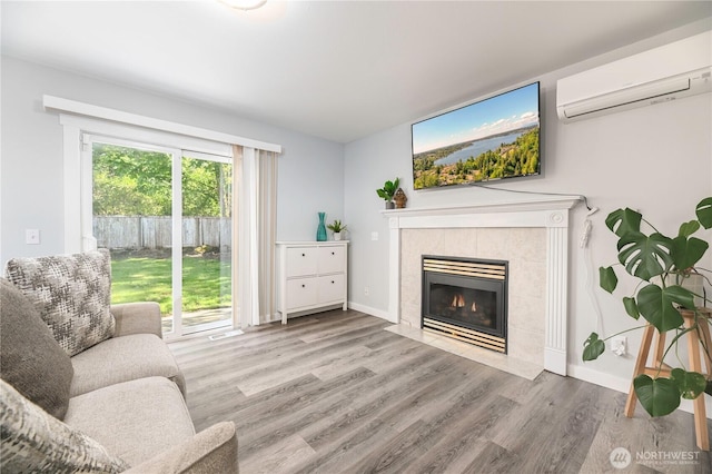 1416 116th Dr SE, Lake Stevens, WA 98258 - living room featuring a wall mounted AC, wood finished floors, a tiled fireplace, and baseboards
