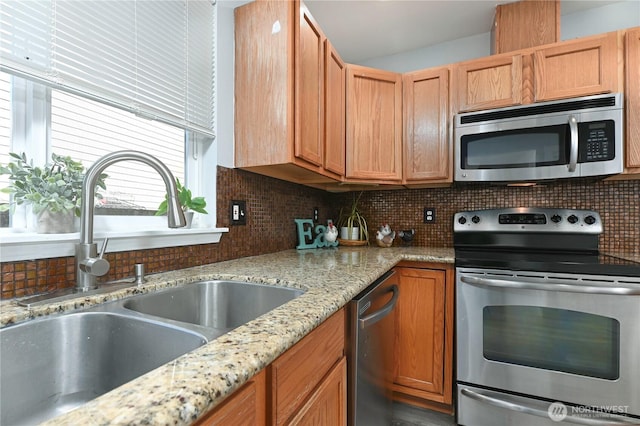 1416 116th Dr SE, Lake Stevens, WA 98258 - kitchen with appliances with stainless steel finishes, a sink, tasteful backsplash, and light stone countertops