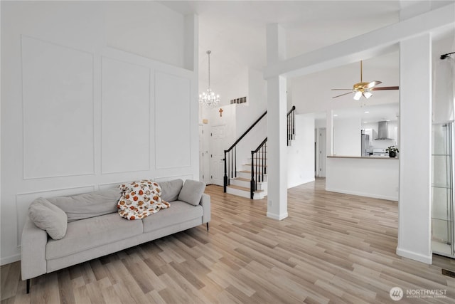 12018 SE 312th Pl Unit 3B, Auburn, WA 98092 - living room with high vaulted ceiling, stairs, a ceiling fan, a chandelier, and light wood-type flooring