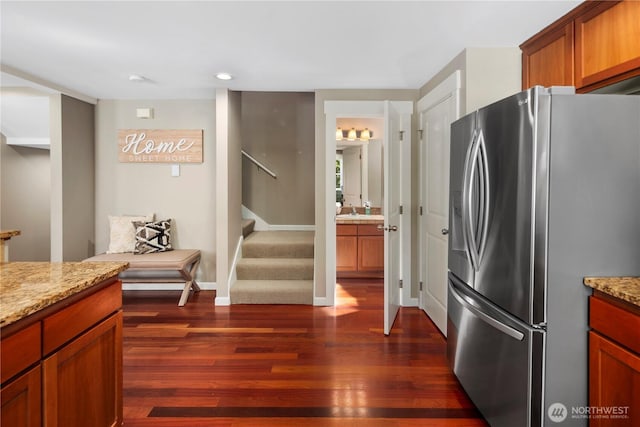 830 15th Ave Unit A, Seattle, WA 98122 - kitchen with stainless steel refrigerator with ice dispenser, dark wood-style flooring, light stone counters, baseboards, and brown cabinets